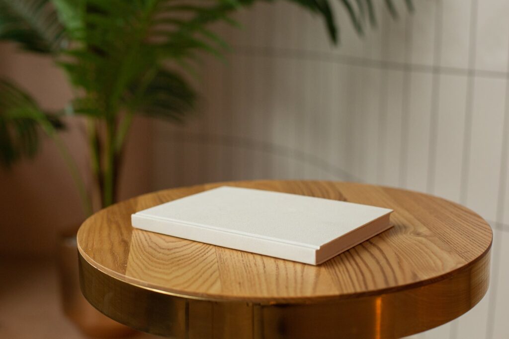 livro branco em cima de mesa de madeira